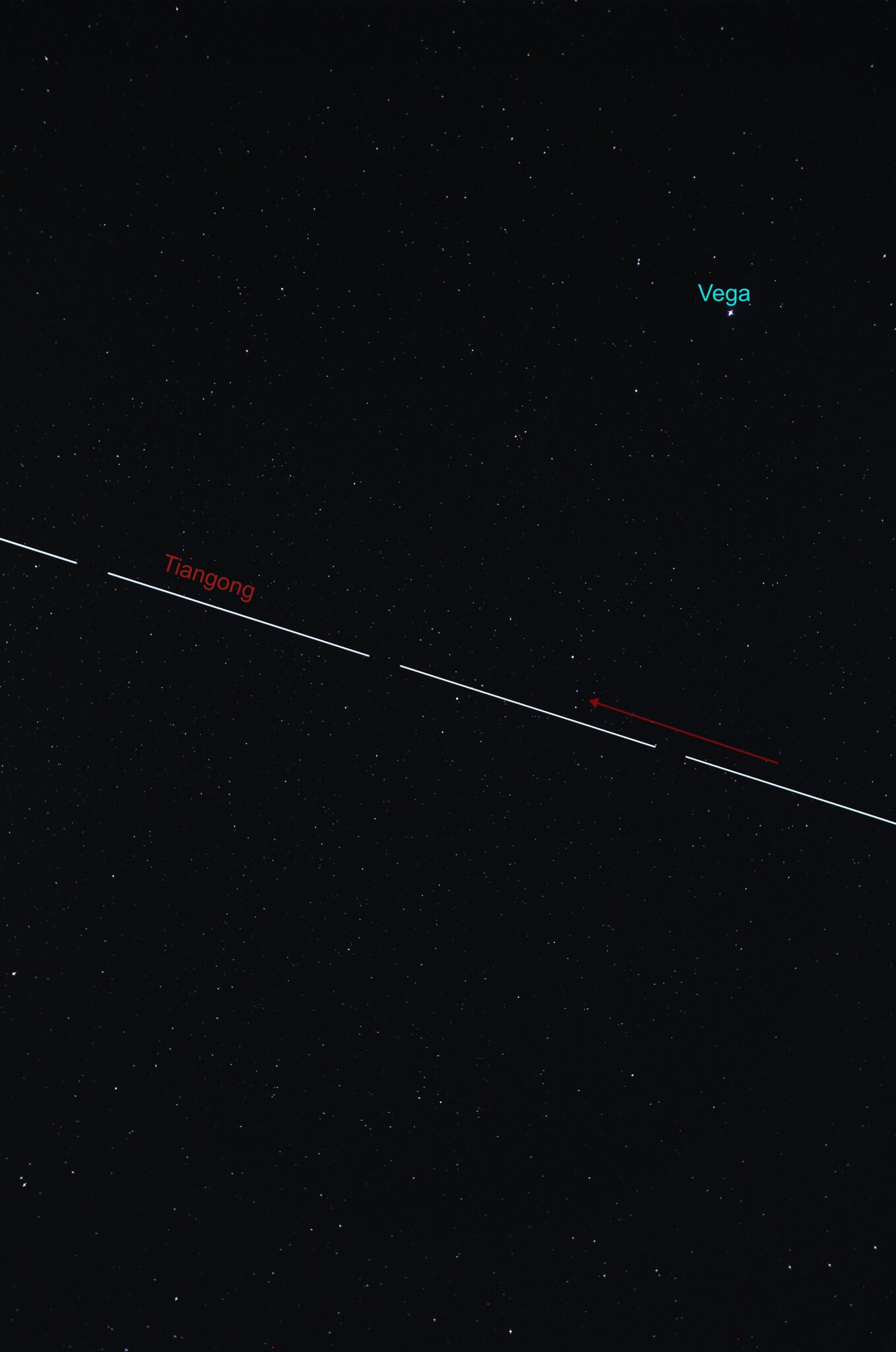 streak of white light across the sky is the tiangong space station beneath Vega.