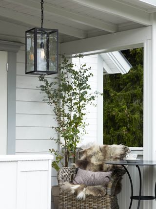 A small porch is illuminated by a lantern