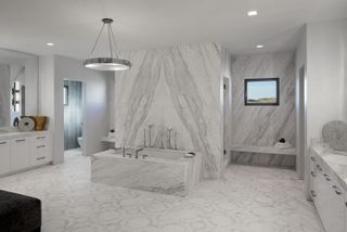 A marble clad bathroom with large chandelier