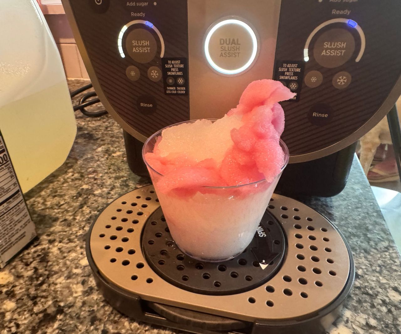 A pink and white drink on the drip tray of the Ninja Slushi Twist