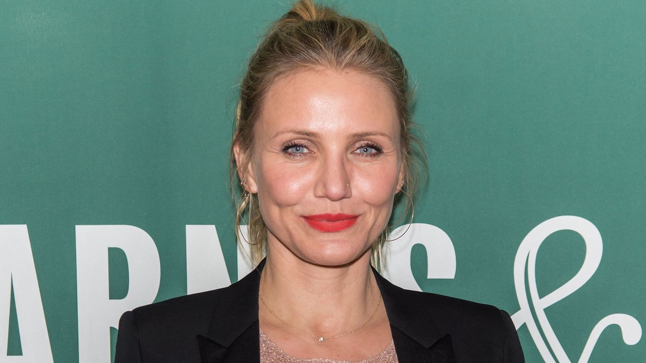 Cameron Diaz&#039;s Kitchen has set our tongues wagging. Here is Cameron a white woman with blonde hair and red lipstick wearing a black blazer, standing in front of a green background with white lettering