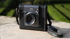 Fujifilm Instax Wide Evo instant camera outdoors in the sun on a stone surface