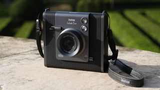 Fujifilm Instax Wide Evo instant camera outdoors in the sun on a stone surface