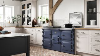 blue Everhot range cooker in kitchen with exposed brick floor and beams