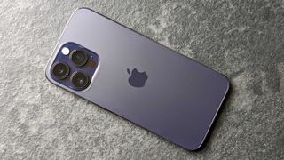 En mobiltelefon av typen iPhone 14 Pro Max med baksiden vendt opp.