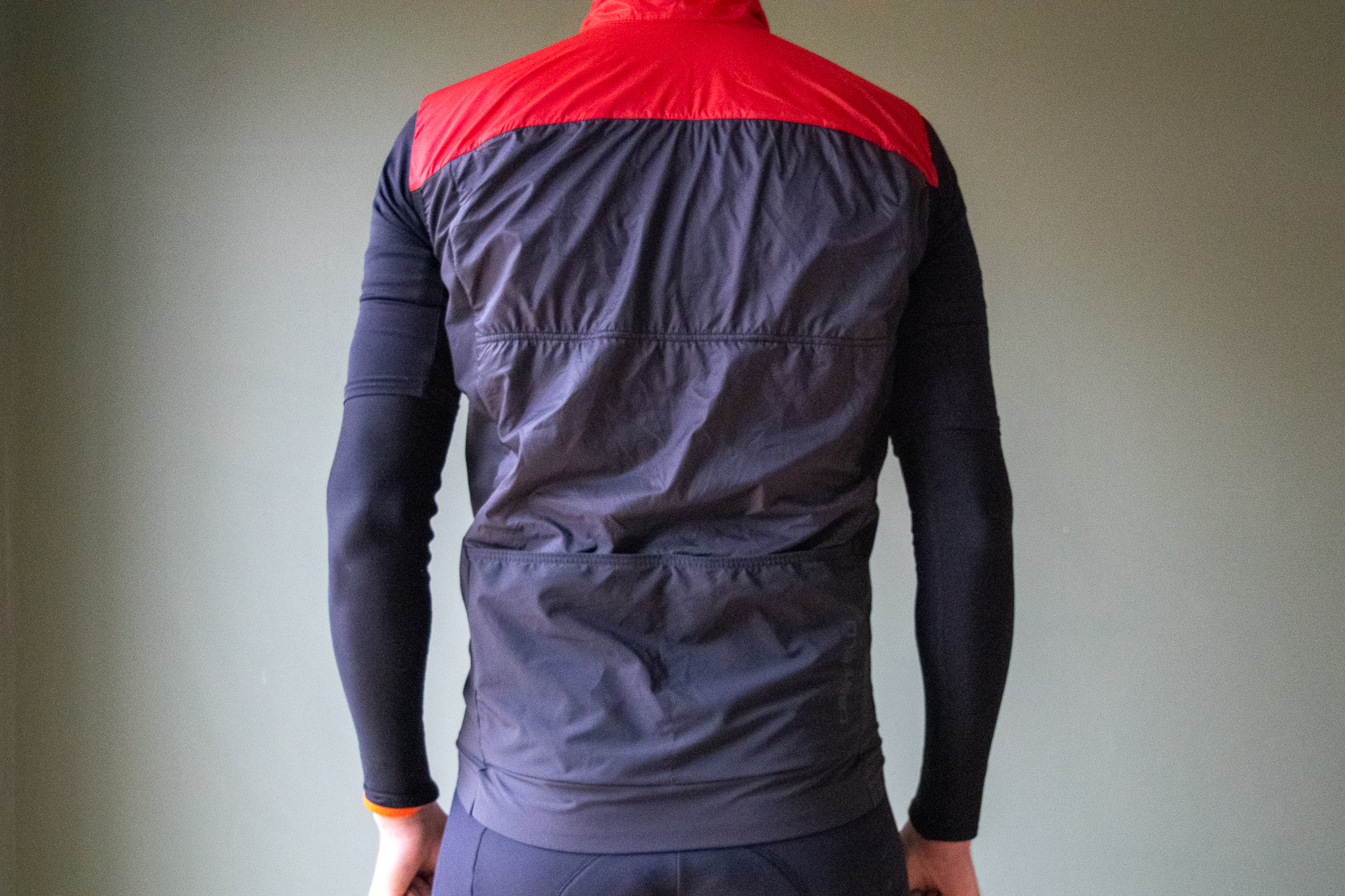 A male cyclist wearing a red Castelli Unlimited Puffy vest