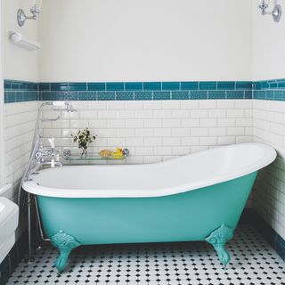 coastal bathroom with blue painted bath, black and white floor tiles, turquoise feature wall tiles