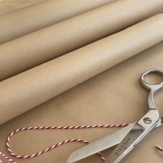Rolls of brown paper, red and white twine, silver scissors