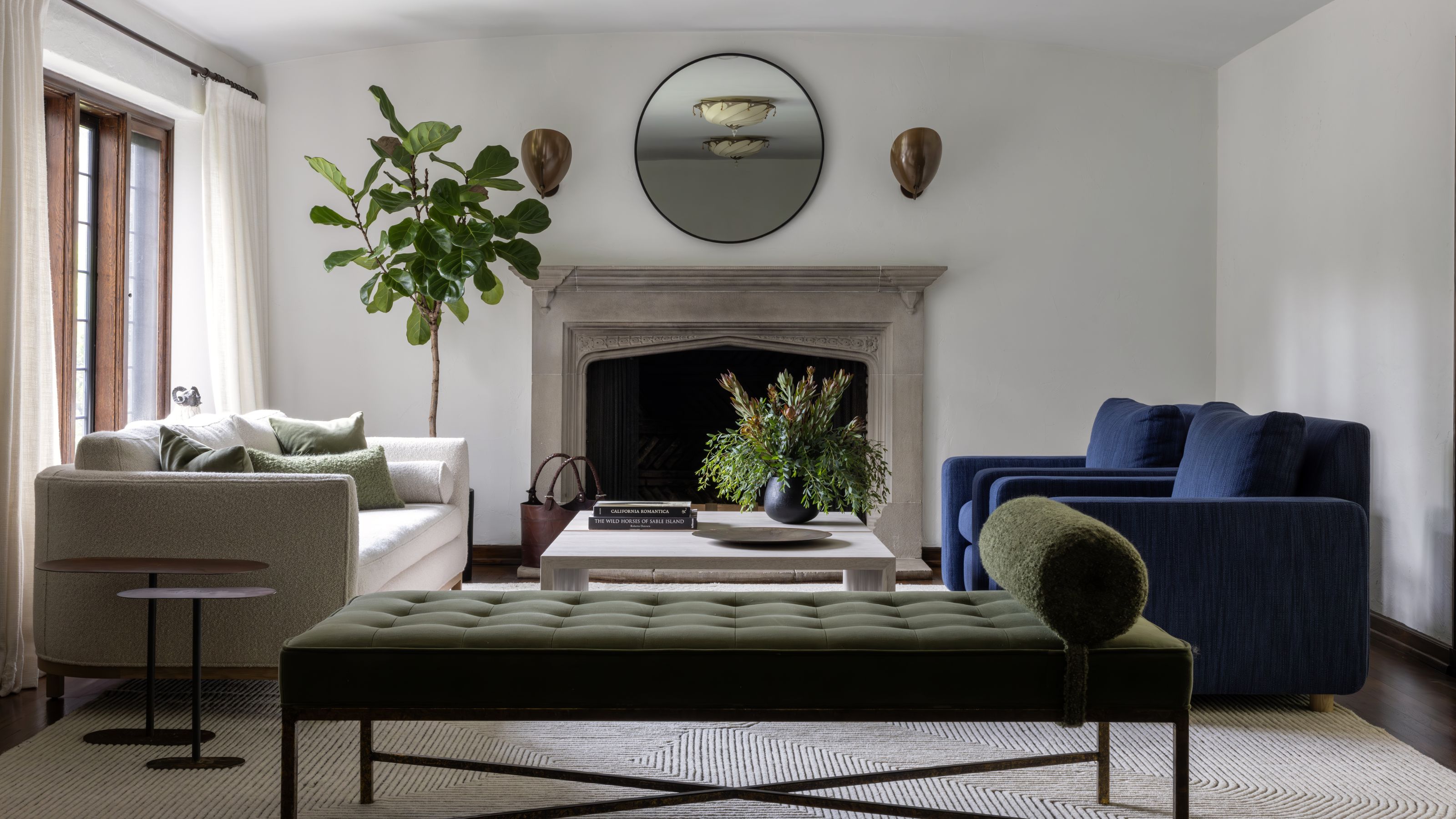 A gorgeous modern living room with a white couch and a blue couch, plus a green daybed in the foreground.