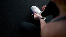 Woman tying shoelaces in gym