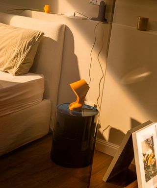 A bedside lamp made from waste materials in a bedroom setting