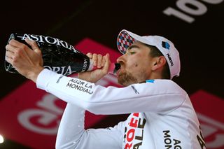 Aurélien Paret-Peintre drinks prosecco on the podium after winning stage four of the Giro d'Italia 2023 at Lago Laceno