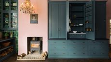 Open dark teal pantry with kitchen fireplace and glass cabinets above tiled walls