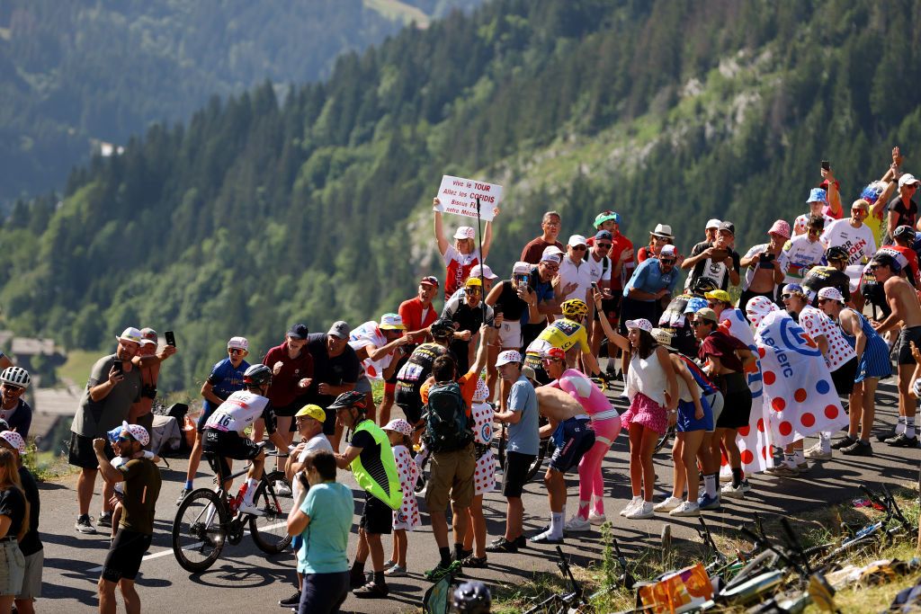 Rafal Majka (UAE Team Emirates) and Sepp Kuss and Jonas Vingegaard of JumboVisma climb the Col des Aravis while fans cheer during stage 15