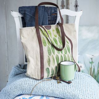 white wooden chair with handbag and green cup
