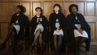 Norelle Morris (Shamia Phills), Rosalind Clifford (Natalie Quarry), Kathy Downes (Rachel Nicholson), Joyce Highland (Renee Bailey) in pupil midwives' uniforms sit in a row in Call the Midwife.