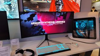 Alienware AW3423DW on a table next to an Aurora gaming PC and an Alienware gaming keyboard. 