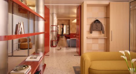 A jewel-box of a retail space with chrome pillars, chrome and lacquered red shelving units, a yellow two-seater couch, wooden wardrobes, and terrazzo flooring.