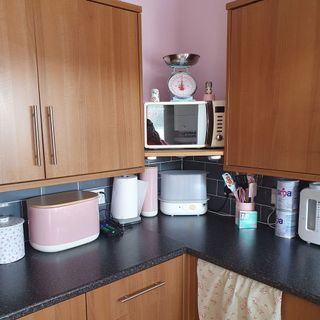 room with hand weight machine marble worktop and wooden cabinet