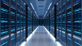 Data center server room with racks pictured on either side with walkway down the middle. 