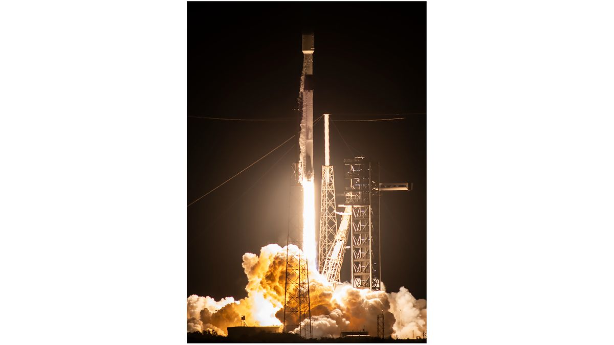 a black and white rocket launches into a night sky.