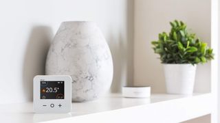 how to heat your home: smart thermostat on styled shelf