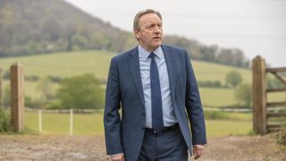 Neil Dudgeon in a suit in the countryside in Midsomer Murders