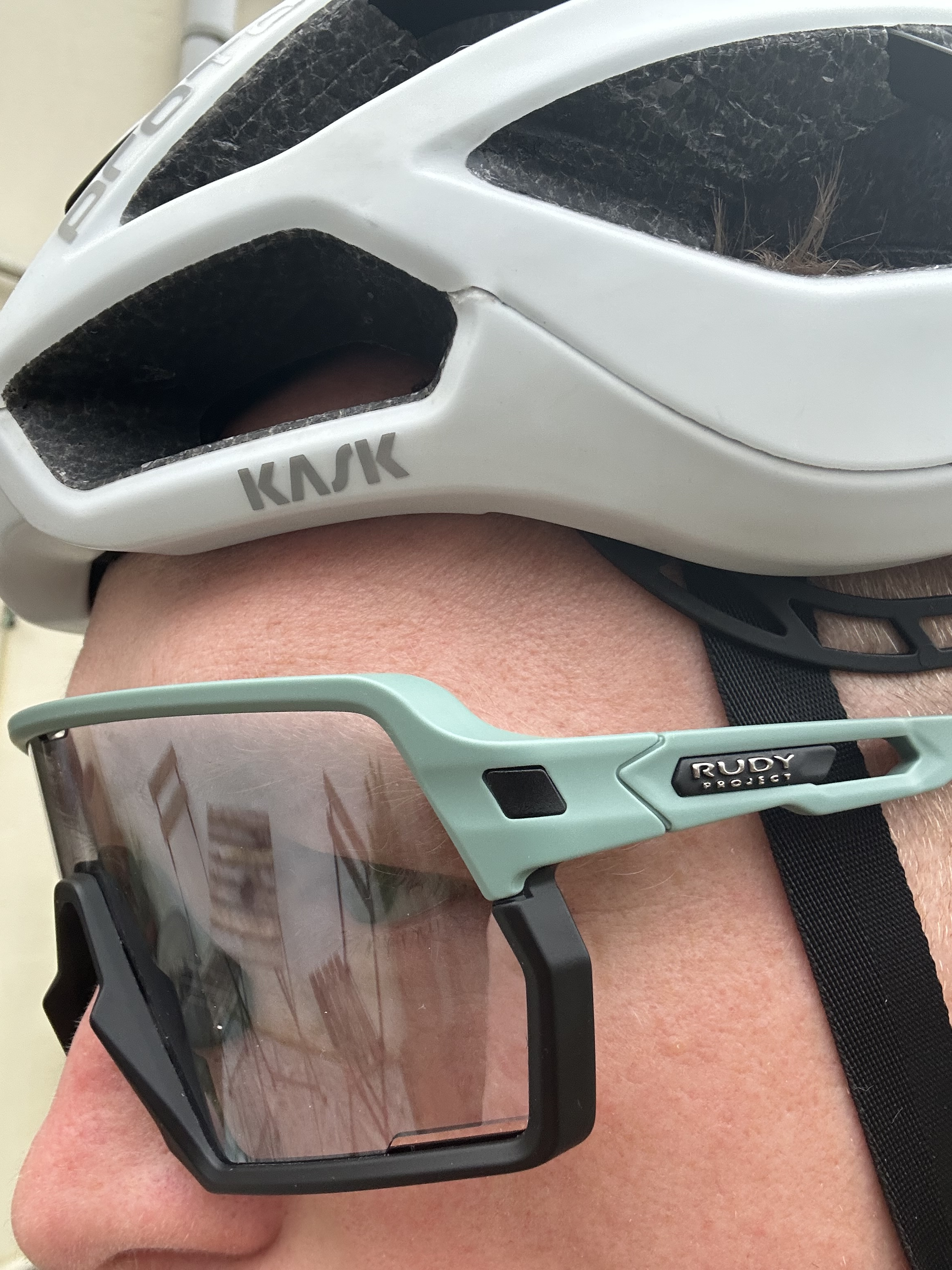 A man wears sunglasses under a bike helmet