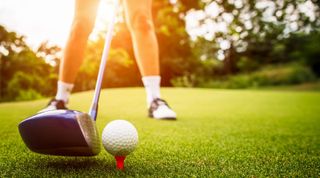 Golfer putting the ball into the hole. - stock photo