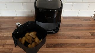 The Proscenic T22 Air Fryer with chicken wings in its frying basket