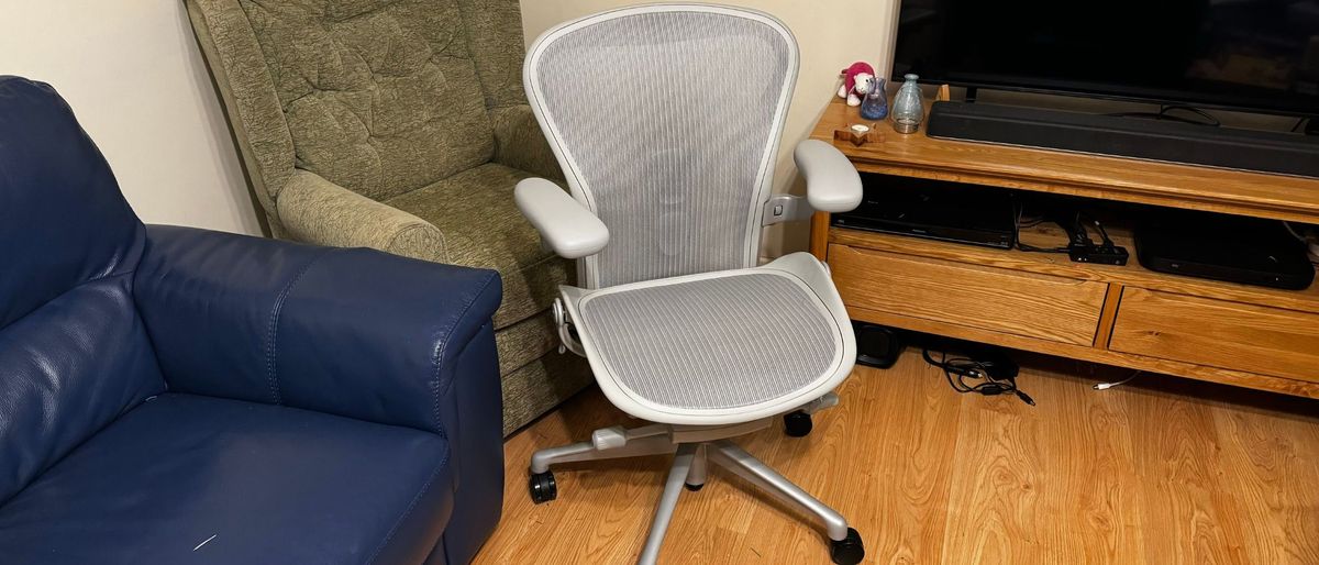 Herman Miller Aeron office chair in front of a sofa