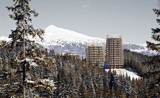 Two high rise residence blocks in the distance near by snowy mountains