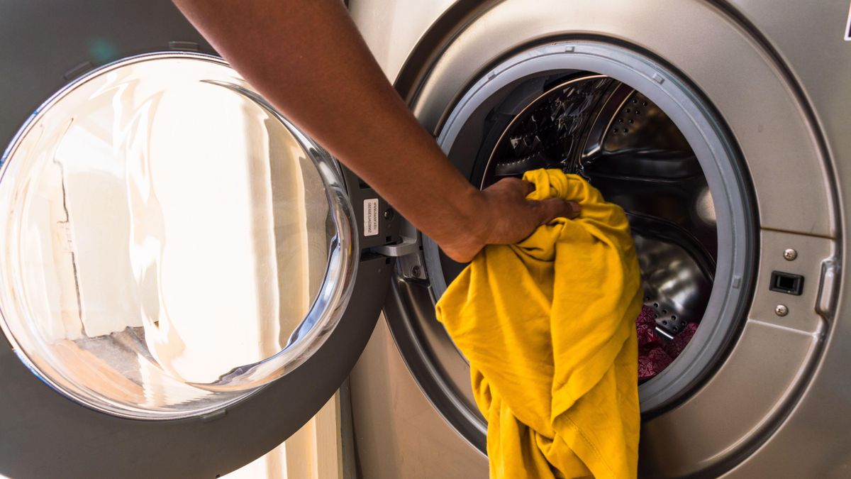 Man loading clothes into washing machine