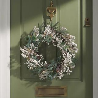 Mistletoe and pine cone christmas wreath on front door