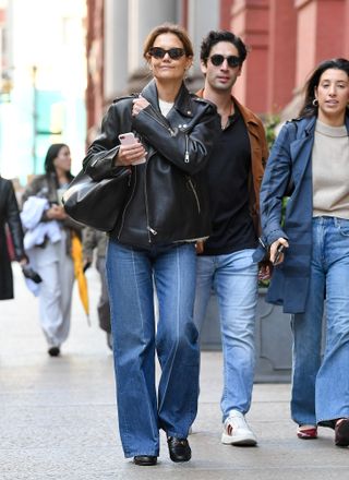 Katie Holmes walking in SoHo in Manhattan wearing a leather biker jacket with jeans, gucci loafers, and a mansur gavriel bag