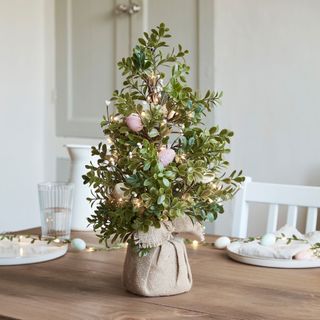 dining table with easter egg tree and light cord