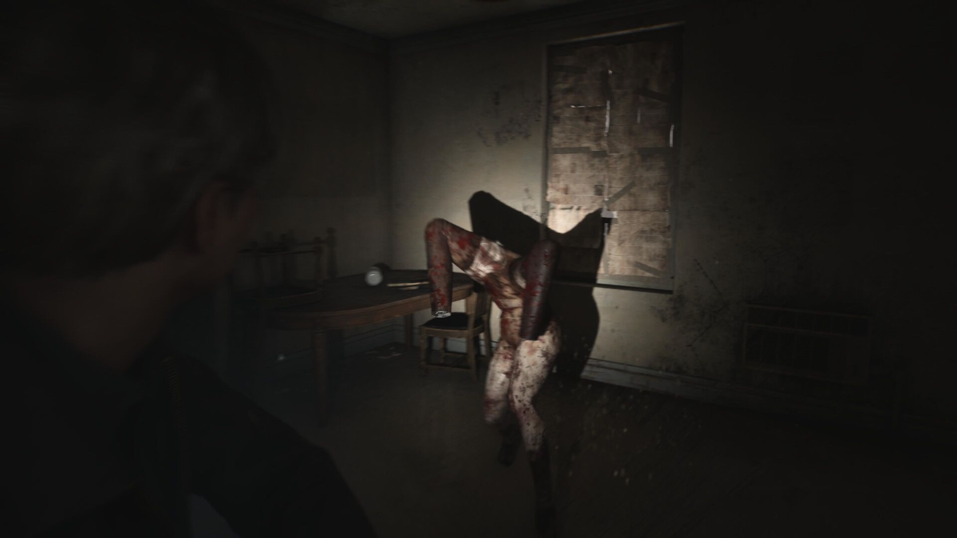 James aims a flashlight at a mannequin, which casts a spindly shadow behind it in Silent Hill 2 remake