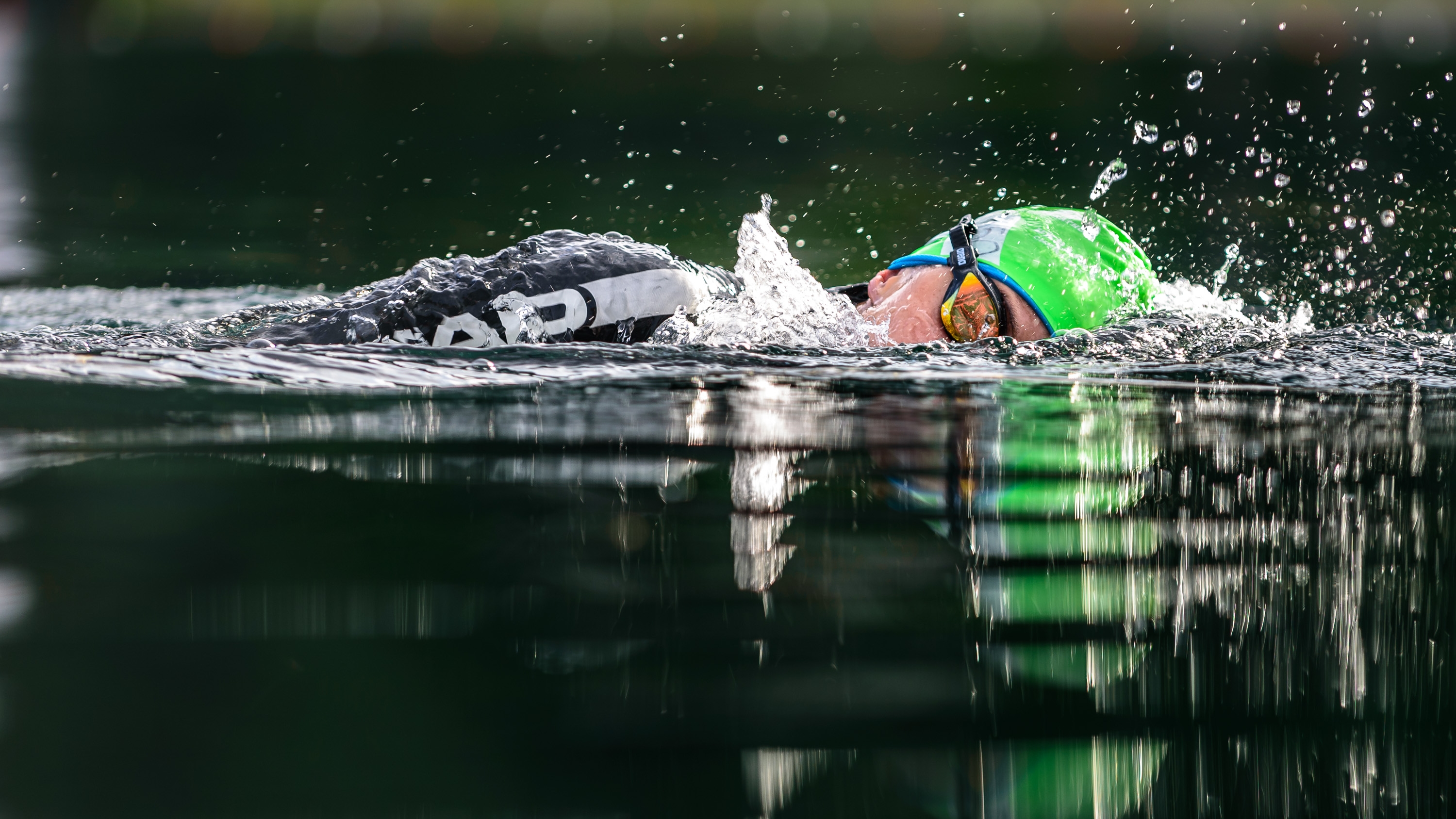 A woman in a wetsuit swimming in an open water lake