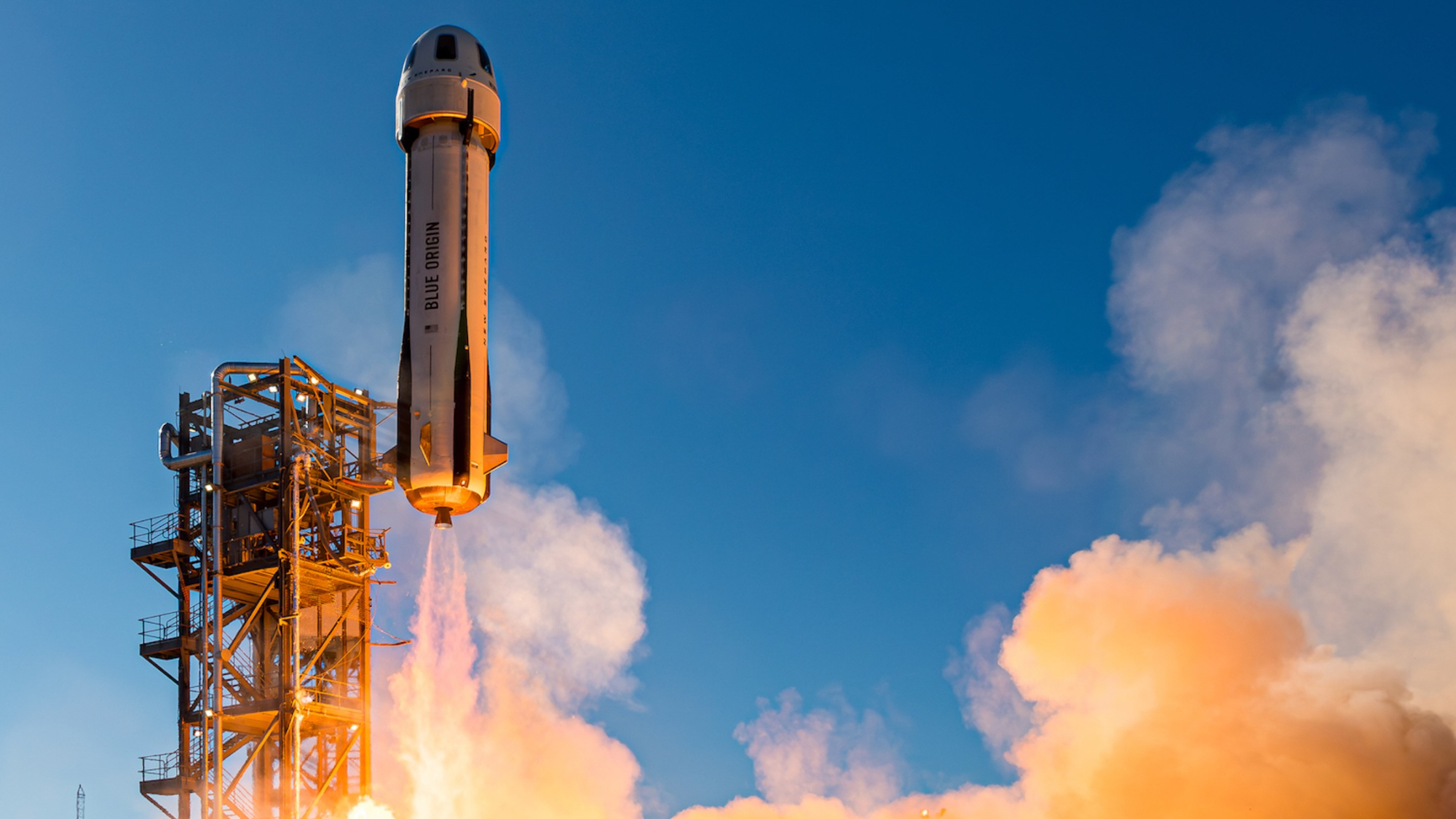a white rocket launches into a blue sky, kicking up a plume of dust
