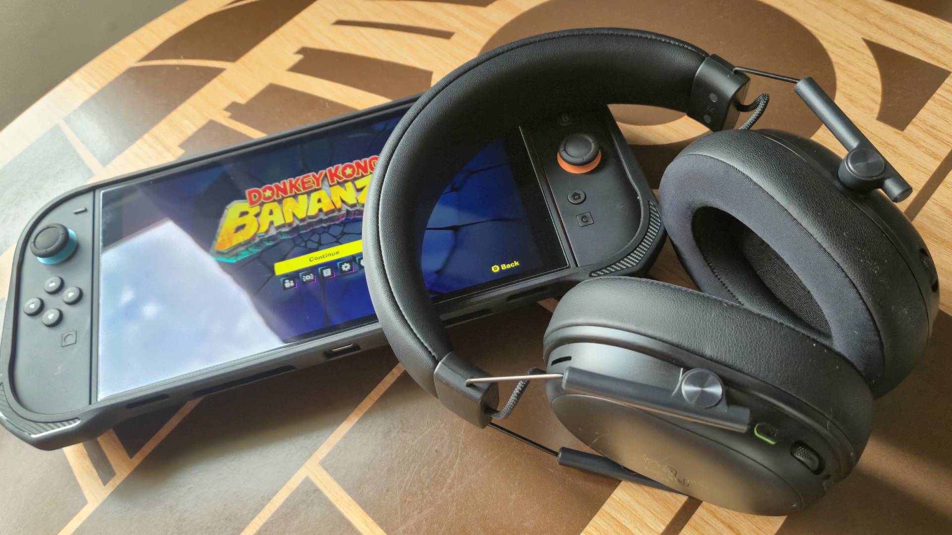 Photo by Rosalie Newcombe of the BlackShark V3 X HyperSpeed gaming headset laying on top of a Switch 2 that&#039;s playing Donkey Kong Bananza.