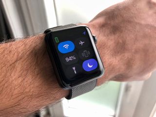 An Apple Watch affixed to a wrist shows Control Center open and Do Not Disturb enabled.