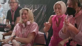 Greta Gerwig and Margot Robbie laughing on the Barbie set