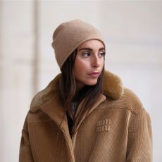 benefit hoola bronzer - woman in beige hat and beige coat looking over her shoulder with warm bronzer skin - gettyimages 1816210836