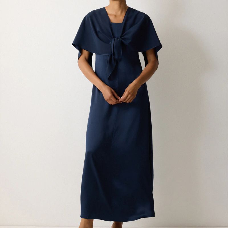 A model wears a navy cape dress by Jigsaw