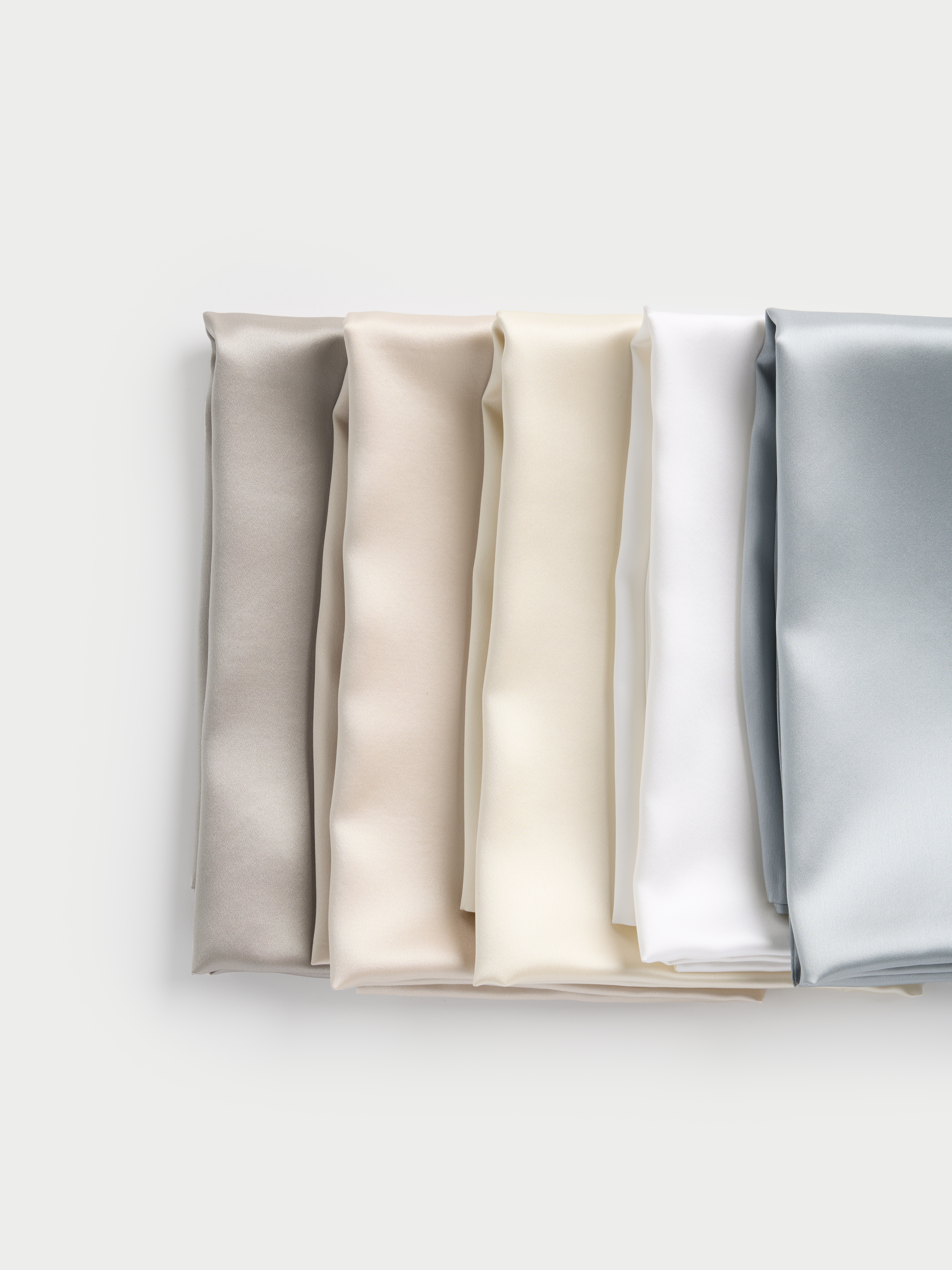 silk pillowcases in different pastel colors on a light background