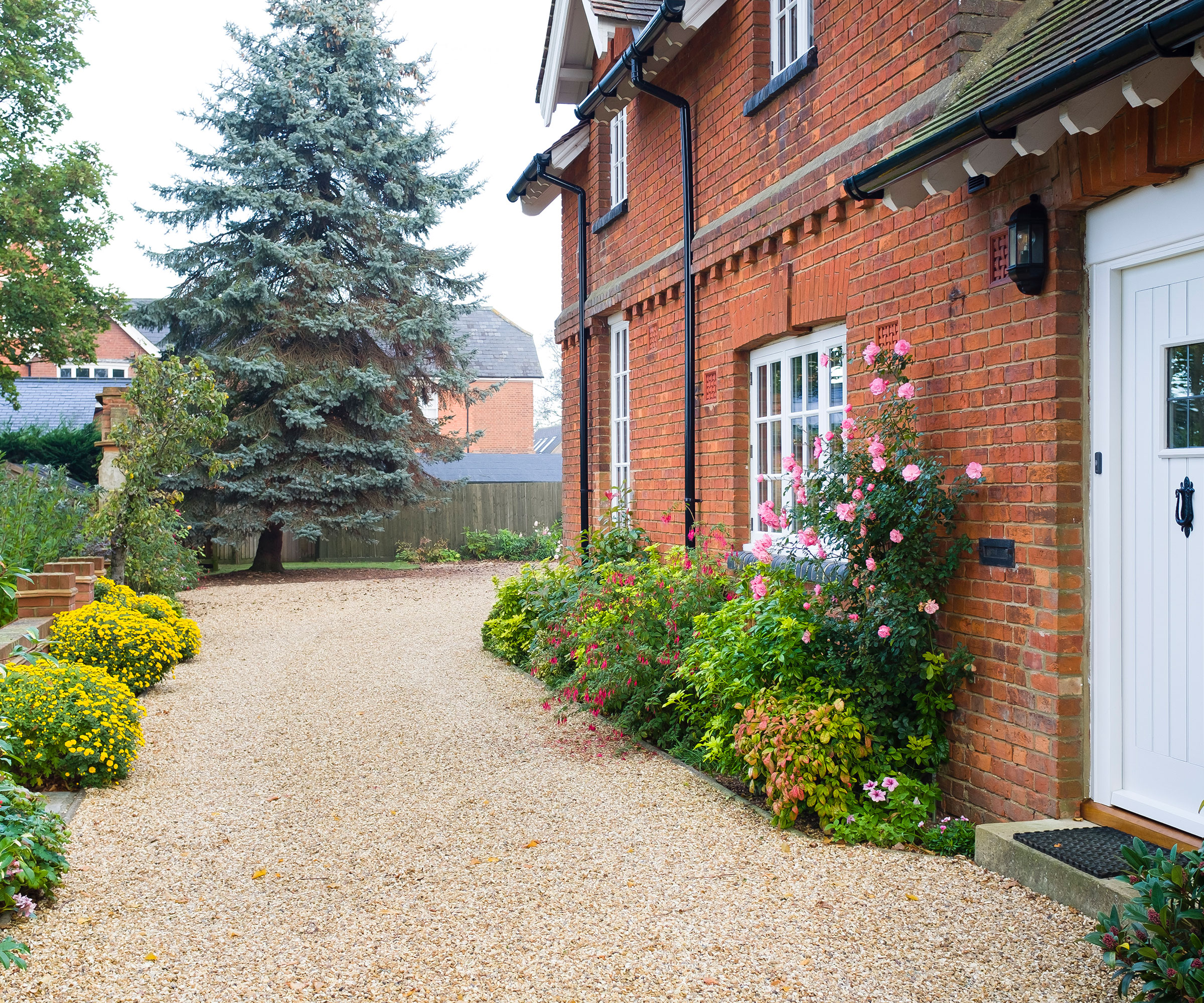 brick Victorian house with gravel driveway