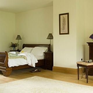 bedroom with cream wall and wooden bed