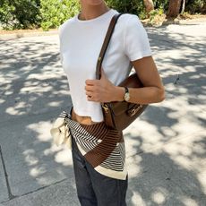 Elsa Hosk wearing a white Helsa T-shirt, Gucci bag, jeans, and scarf belt