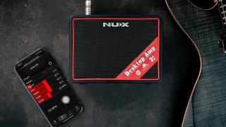 A NUX Mighty Lite BT MKII mini amp with a smartphone and electric guitar