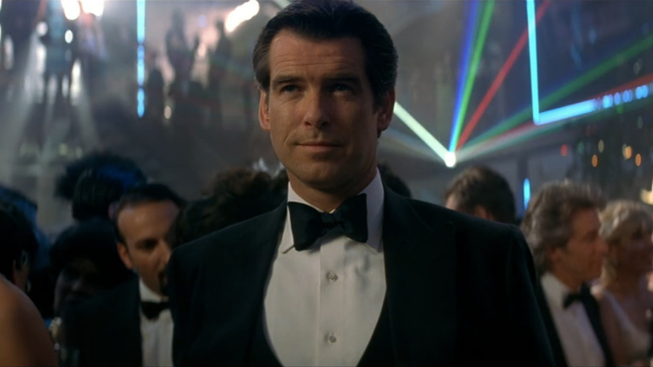 Pierce Brosnan grins in the middle of a crowded Tomorrow Never Dies party.